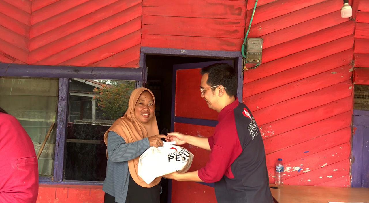 Branch Director Bank Artha Graha Internasional Tbk Kota Pekanbaru, Salut Laksanawan membagikan paket sembako murah kepada Nurliah, salah seorang penerima program AGP, Rabu (17/12/2025). Foto Ist